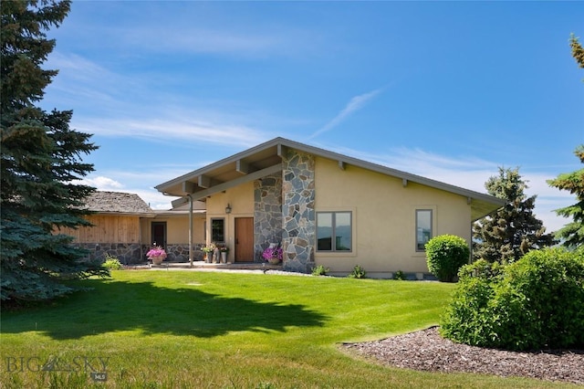 1520 Black Bull Trl, Bozeman, MT 59718 - rear view of property featuring stone siding, stucco siding, and a yard