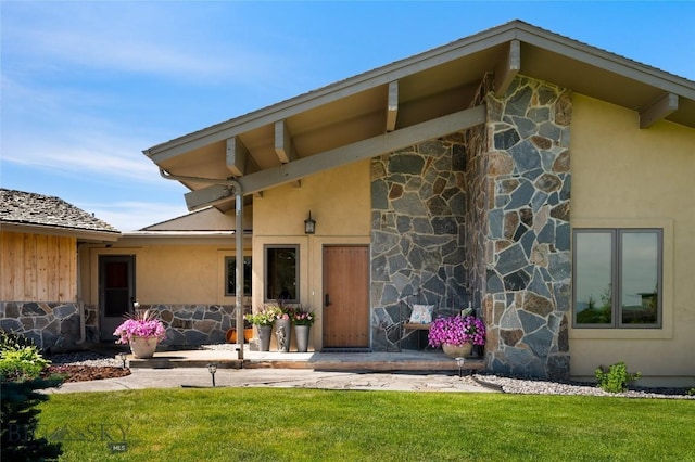 1520 Black Bull Trl, Bozeman, MT 59718 - entrance to property featuring stone siding, a lawn, and stucco siding