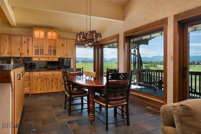 1520 Black Bull Trl, Bozeman, MT 59718 - dining area with stone tile floors, a chandelier, vaulted ceiling, and a mountain view