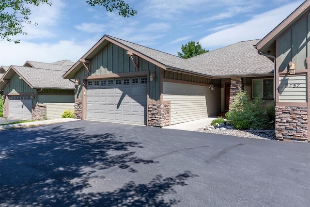 2757 Marlyn Ct Unit 1, Bozeman, MT 59718 - view of front facade featuring board and batten siding, stone siding, a shingled roof, and a garage