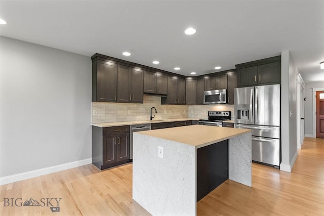 2757 Marlyn Ct Unit 1, Bozeman, MT 59718 - kitchen featuring appliances with stainless steel finishes, dark brown cabinetry, light countertops, backsplash, and recessed lighting