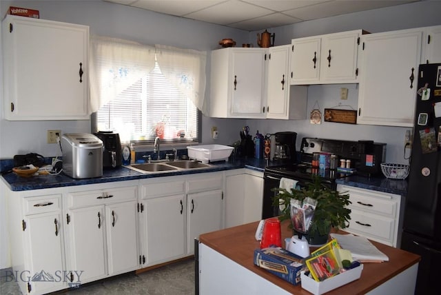 2200 Elm, Butte, MT 59701 - kitchen featuring range with electric stovetop, freestanding refrigerator, dark countertops, white cabinets, and a paneled ceiling