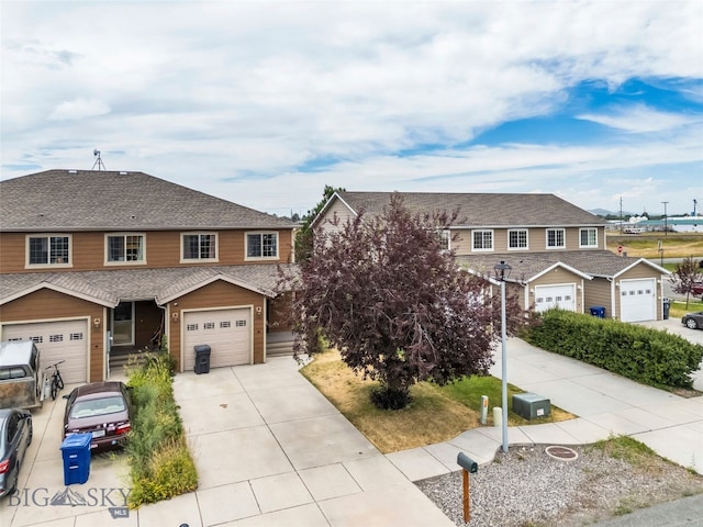 1110 Biehl Unit C, Belgrade, MT 59714 - view of front of house with concrete driveway, a garage, a residential view, and roof with shingles
