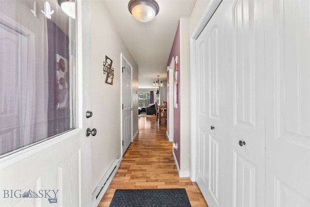 1110 Biehl Unit C, Belgrade, MT 59714 - hall with a baseboard radiator, light wood-type flooring, and a chandelier