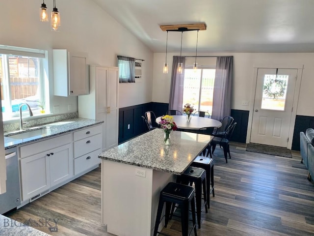 801 Pleiades Pl, Livingston, MT 59047 - kitchen featuring dishwasher, wood finished floors, white cabinetry, lofted ceiling, and light stone counters