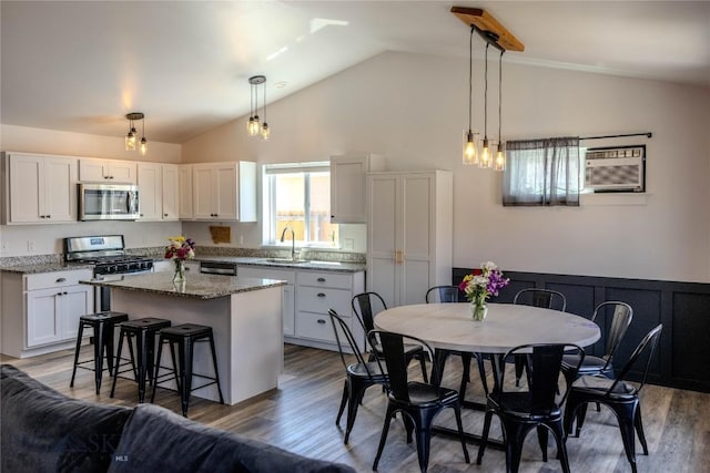 801 Pleiades Pl, Livingston, MT 59047 - kitchen with stainless steel appliances, white cabinetry, a kitchen island, a kitchen breakfast bar, and light stone countertops