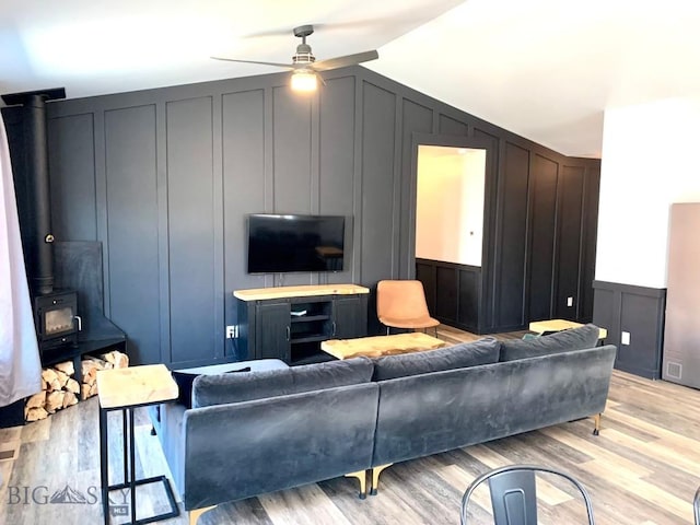 801 Pleiades Pl, Livingston, MT 59047 - living room with a decorative wall, ceiling fan, light wood finished floors, a wood stove, and lofted ceiling