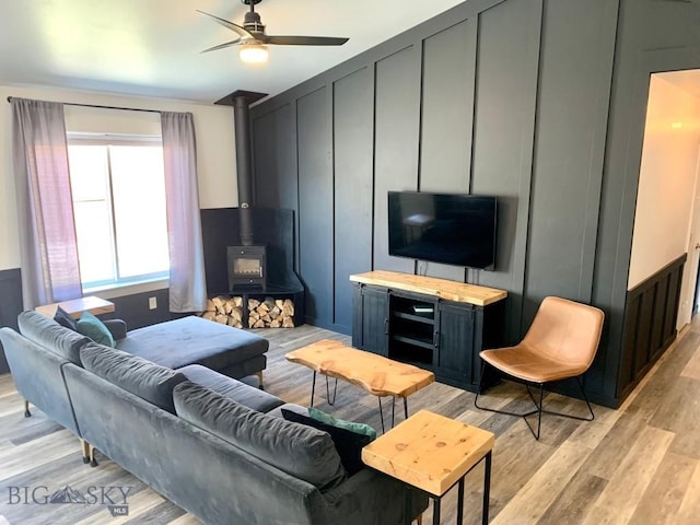 801 Pleiades Pl, Livingston, MT 59047 - living room featuring light wood-style floors, a wood stove, ceiling fan, and a decorative wall