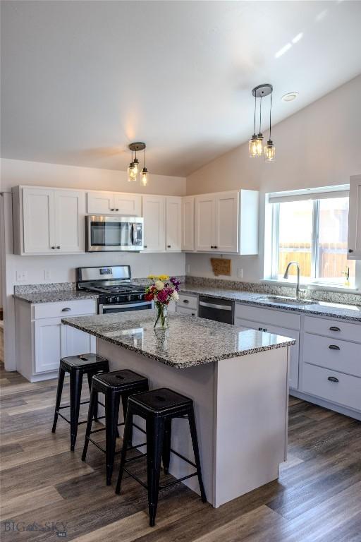 801 Pleiades Pl, Livingston, MT 59047 - kitchen with stainless steel appliances, a kitchen island, white cabinetry, a kitchen bar, and lofted ceiling