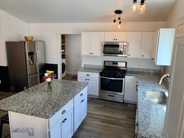 801 Pleiades Pl, Livingston, MT 59047 - kitchen featuring appliances with stainless steel finishes, washer / dryer, light stone counters, and white cabinetry