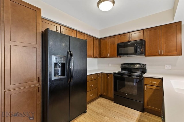 210 S Cottonwood Rd Unit 308, Bozeman, MT 59718 - kitchen featuring black appliances, light countertops, light wood-style floors, and brown cabinetry