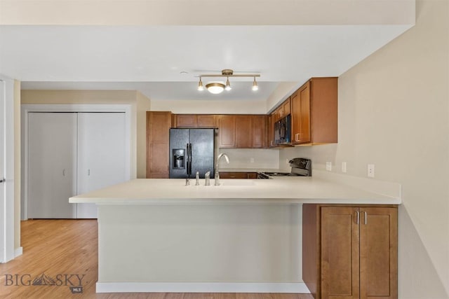 210 S Cottonwood Rd Unit 308, Bozeman, MT 59718 - kitchen featuring refrigerator with ice dispenser, black microwave, range, and brown cabinetry