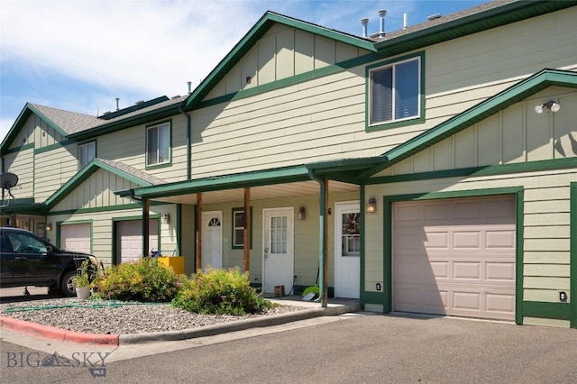 1132 Cruiser Ln Unit F, Belgrade, MT 59714 - townhome / multi-family property featuring covered porch, board and batten siding, asphalt driveway, and a garage