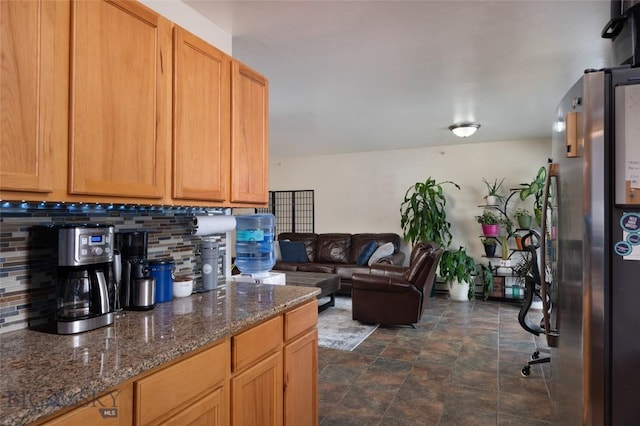 1132 Cruiser Ln Unit F, Belgrade, MT 59714 - kitchen with backsplash, stone finish flooring, dark stone countertops, and open floor plan