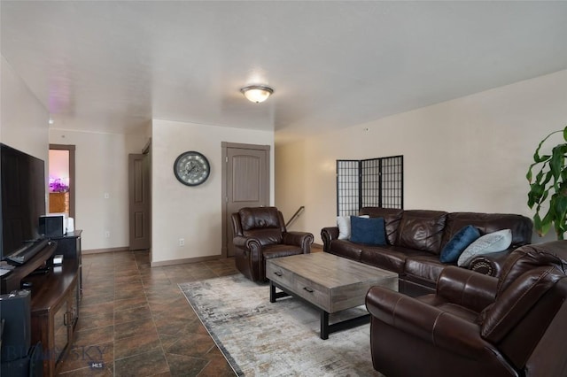 1132 Cruiser Ln Unit F, Belgrade, MT 59714 - living room featuring dark stone finish floors and baseboards