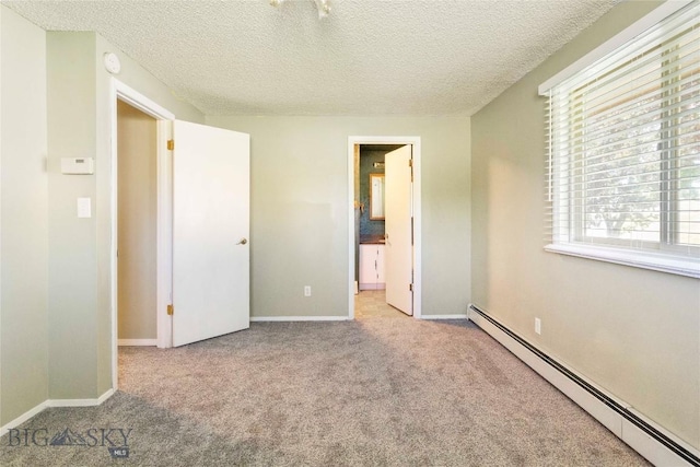 34 Mammoth Dr, Butte, MT 59701 - unfurnished bedroom featuring baseboard heating, carpet flooring, multiple windows, and a textured ceiling