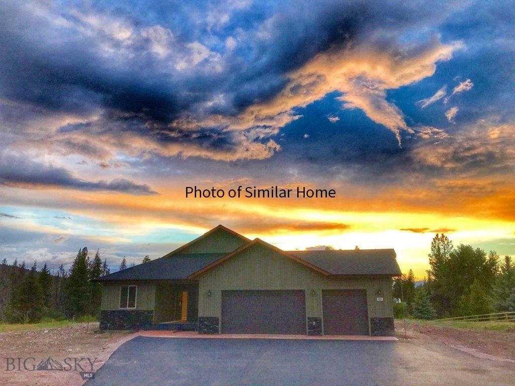 312 Dunham Ct, Seeley Lake, MT 59868 - view of front of house featuring a garage, driveway, and stucco siding