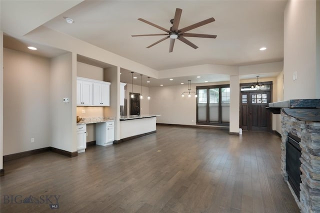 5479 Annie St, Bozeman, MT 59718 - unfurnished living room with a ceiling fan, dark wood finished floors, a fireplace, and a chandelier