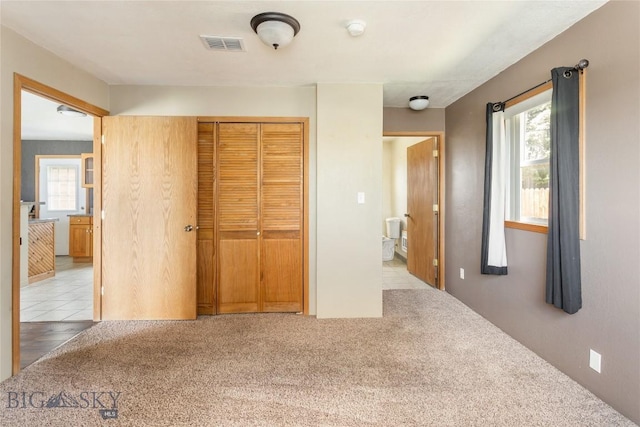 735 10th St, Butte, MT 59701 - unfurnished bedroom with a closet, multiple windows, and carpet flooring