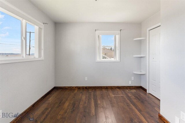 735 10th St, Butte, MT 59701 - unfurnished bedroom with dark wood-style floors and baseboards