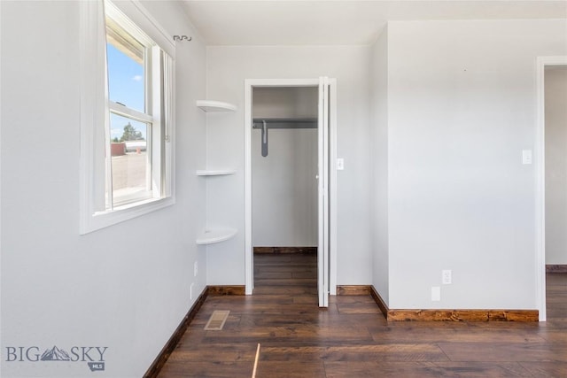 735 10th St, Butte, MT 59701 - unfurnished bedroom featuring a walk in closet, a closet, and wood finished floors