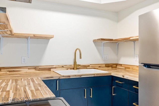 1714 S 19th Ave, Bozeman, MT 59718 - kitchen with freestanding refrigerator, blue cabinets, and wooden counters