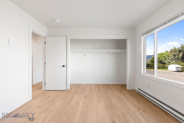 1714 S 19th Ave, Bozeman, MT 59718 - unfurnished bedroom with a baseboard radiator, a closet, and light wood-style floors