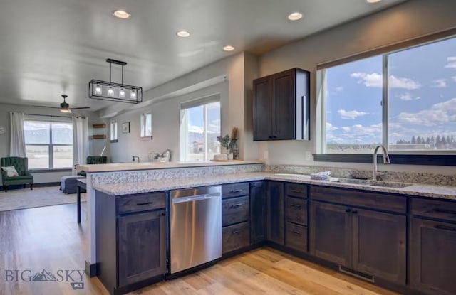 421 Otis Ave, Ennis, MT 59729 - kitchen featuring stainless steel dishwasher, a peninsula, light wood-type flooring, open floor plan, and light stone countertops
