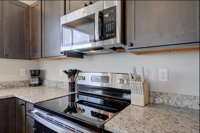 421 Otis Ave, Ennis, MT 59729 - kitchen featuring stainless steel appliances, dark brown cabinets, and light stone counters