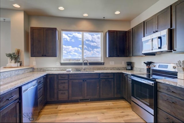421 Otis Ave, Ennis, MT 59729 - kitchen featuring appliances with stainless steel finishes, light stone counters, recessed lighting, light wood finished floors, and dark brown cabinets