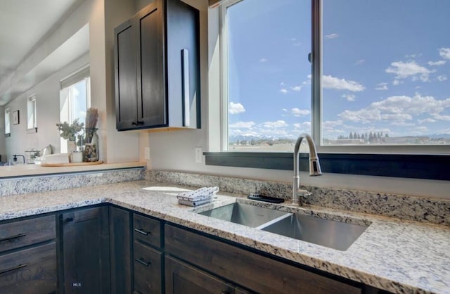 421 Otis Ave, Ennis, MT 59729 - kitchen with plenty of natural light, dark brown cabinets, and light stone counters