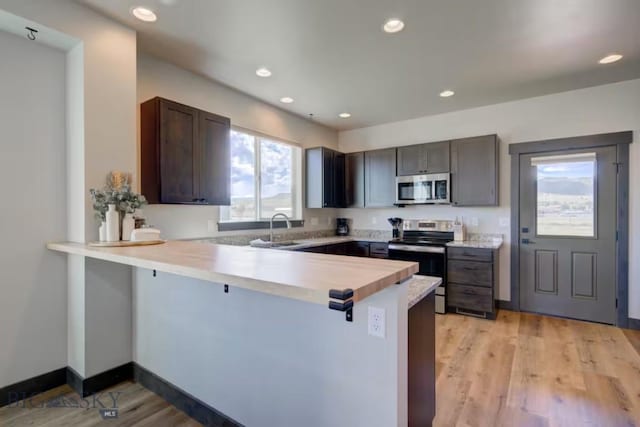 421 Otis Ave, Ennis, MT 59729 - kitchen with appliances with stainless steel finishes, a peninsula, light countertops, recessed lighting, and light wood finished floors