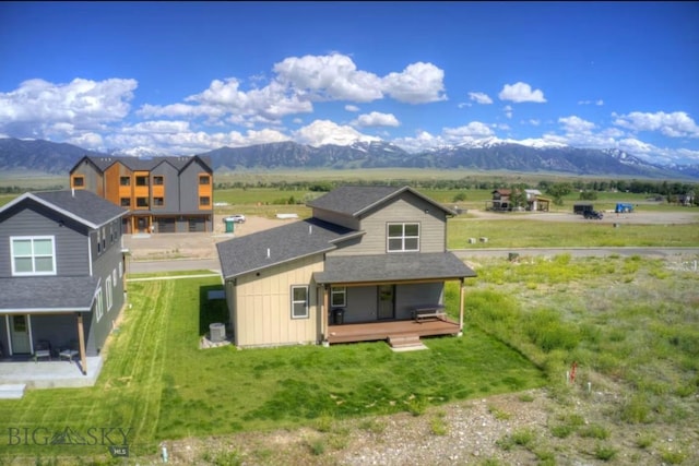 421 Otis Ave, Ennis, MT 59729 - rear view of property featuring a mountain view, board and batten siding, a porch, a yard, and a shingled roof
