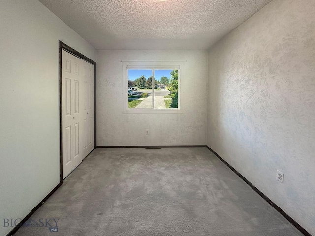 1716 S Rouse, Bozeman, MT 59715 - unfurnished bedroom with a textured ceiling, carpet floors, and a closet