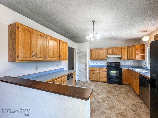 1716 S Rouse, Bozeman, MT 59715 - kitchen with black appliances, a chandelier, decorative light fixtures, under cabinet range hood, and a peninsula