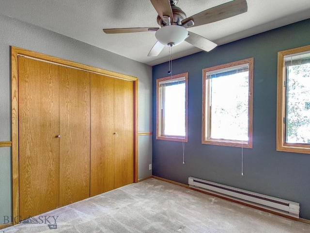 353 Sacajawea Peak Dr, Bozeman, MT 59718 - unfurnished bedroom featuring baseboard heating, multiple windows, a closet, and carpet flooring
