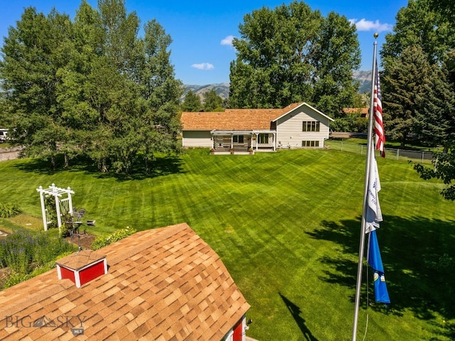 353 Sacajawea Peak Dr, Bozeman, MT 59718 - rear view of property with a shingled roof, a lawn, and a mountain view