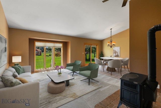 353 Sacajawea Peak Dr, Bozeman, MT 59718 - living room featuring a wood stove, plenty of natural light, a chandelier, a ceiling fan, and lofted ceiling
