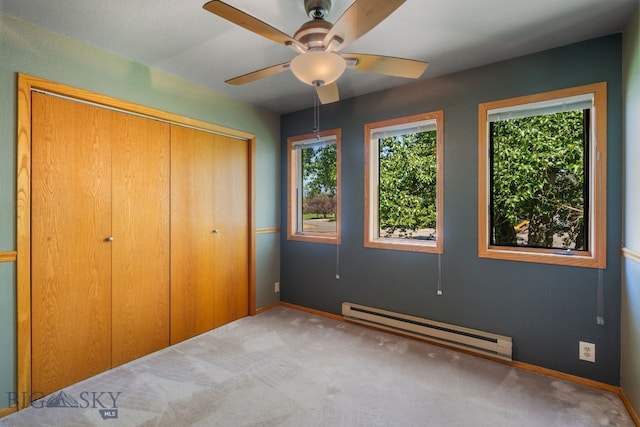 353 Sacajawea Peak Dr, Bozeman, MT 59718 - unfurnished bedroom featuring a baseboard heating unit, multiple windows, a closet, and carpet