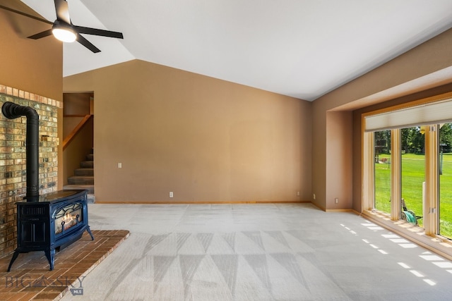 353 Sacajawea Peak Dr, Bozeman, MT 59718 - unfurnished living room featuring lofted ceiling, a wood stove, light carpet, and a ceiling fan