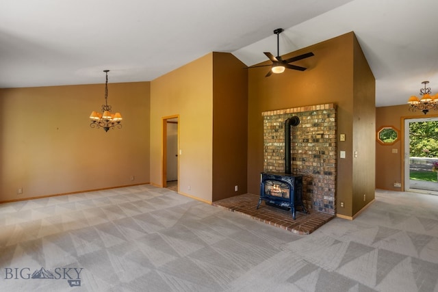 353 Sacajawea Peak Dr, Bozeman, MT 59718 - unfurnished living room featuring a chandelier, carpet, a ceiling fan, a wood stove, and high vaulted ceiling