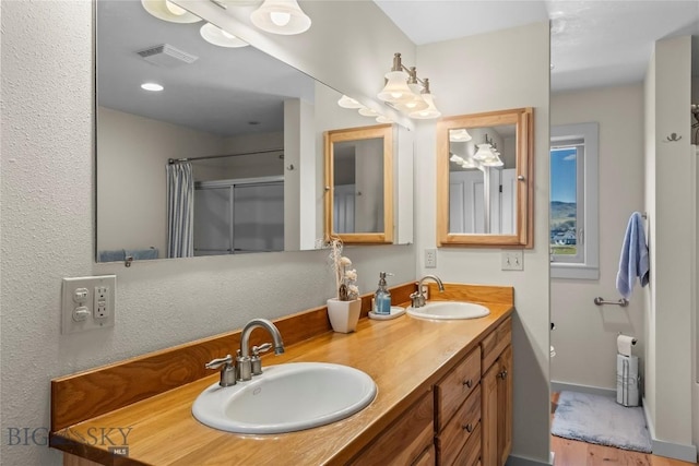 818 N 13th St, Livingston, MT 59047 - full bathroom featuring double vanity, wood finished floors, and a shower with shower curtain
