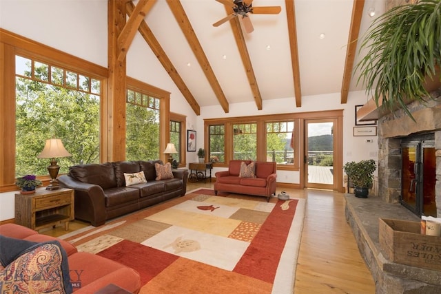 526 Chief Joseph, Big Sky, MT 59716 - living room featuring a stone fireplace, light wood finished floors, beamed ceiling, a ceiling fan, and high vaulted ceiling