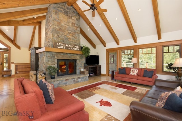526 Chief Joseph, Big Sky, MT 59716 - living area featuring hardwood / wood-style floors, a stone fireplace, high vaulted ceiling, beamed ceiling, and healthy amount of natural light