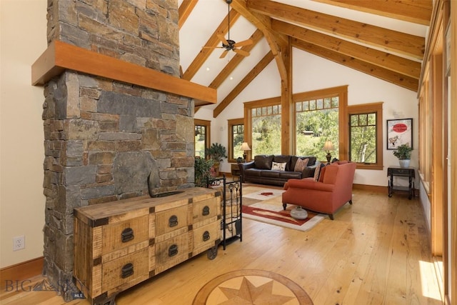 526 Chief Joseph, Big Sky, MT 59716 - living room with hardwood / wood-style flooring, beamed ceiling, high vaulted ceiling, a ceiling fan, and a large fireplace