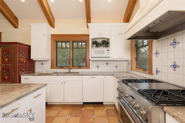 526 Chief Joseph, Big Sky, MT 59716 - kitchen with custom exhaust hood, high end range, beam ceiling, healthy amount of natural light, and white cabinetry