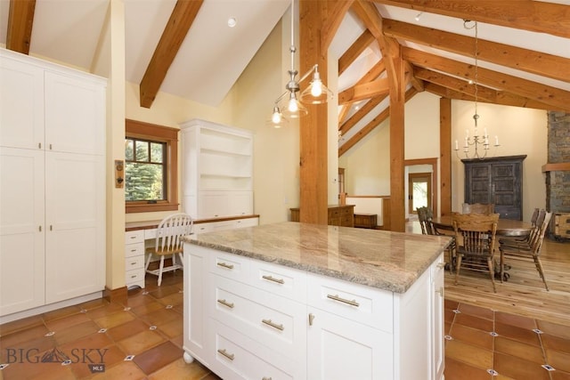 526 Chief Joseph, Big Sky, MT 59716 - kitchen with beam ceiling, a center island, light stone countertops, white cabinets, and built in study area