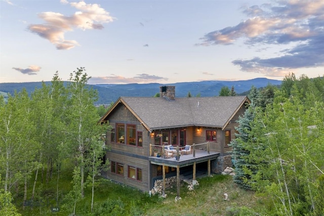 526 Chief Joseph, Big Sky, MT 59716 - rear view of property featuring a chimney, a deck with mountain view, and a shingled roof