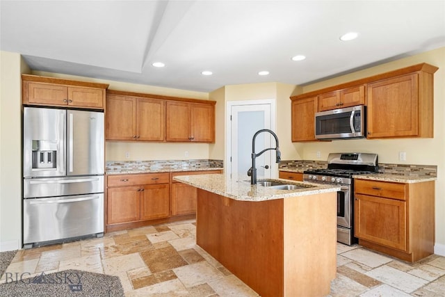 1705 Ingomar Blvd, Belgrade, MT 59714 - kitchen featuring appliances with stainless steel finishes, recessed lighting, light stone countertops, stone tile flooring, and a kitchen island with sink