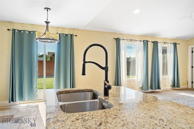 1705 Ingomar Blvd, Belgrade, MT 59714 - kitchen with healthy amount of natural light, hanging light fixtures, light stone countertops, and recessed lighting